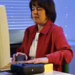 Eine Dame arbeitet in einem Büro an einem Computer. 