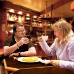 Eine Frau und ein Mann sitzen an einem Tisch in einem Café und unterhalten sich.